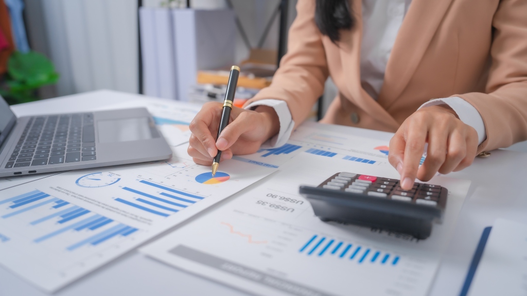 woman looking at taxes and working with calculator