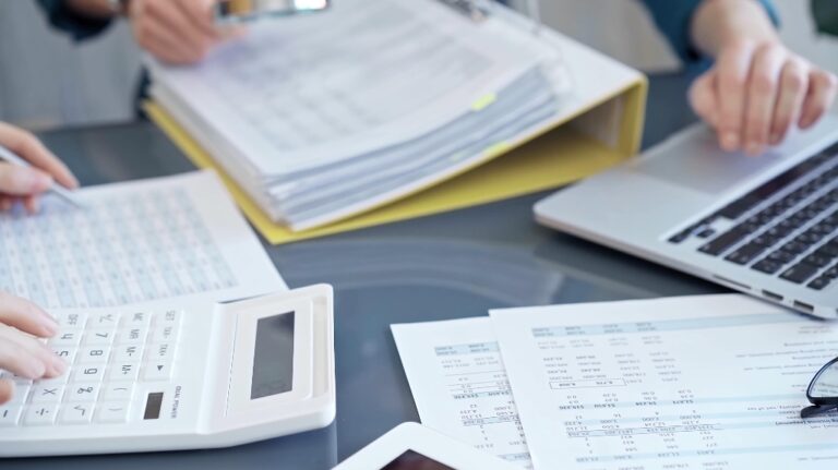 two persons reviewing financial documents and calculating taxes