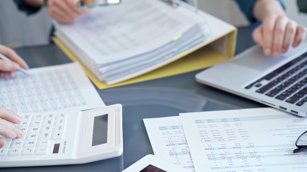 two persons reviewing financial documents and calculating taxes
