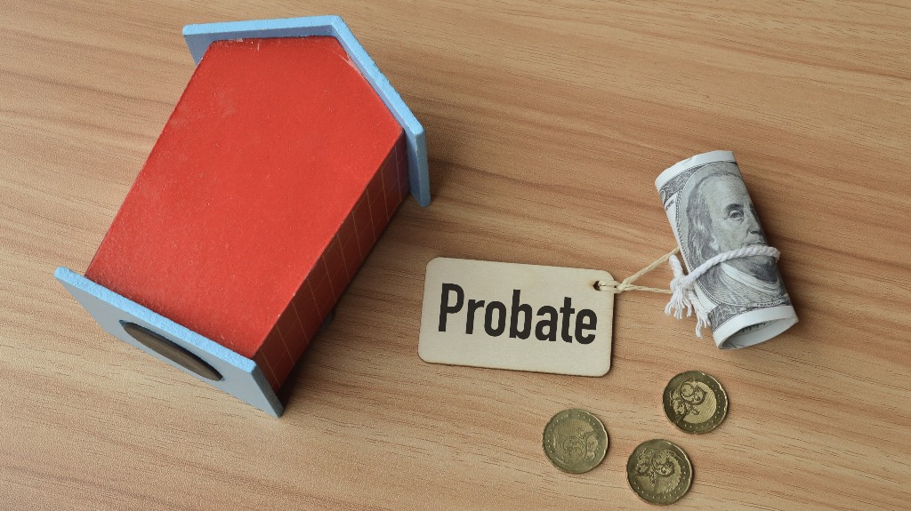 toy wooden house, coins. money banknote and wooden tag written with text PROBATE