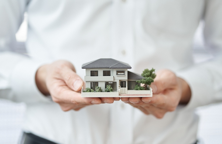 man holding a model of house