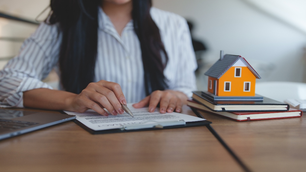 woman writing on notebook with pen