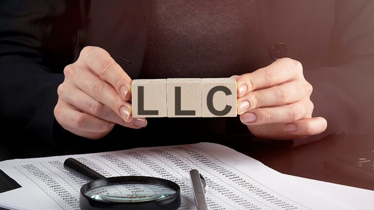 woman holding wooden block with text LLC